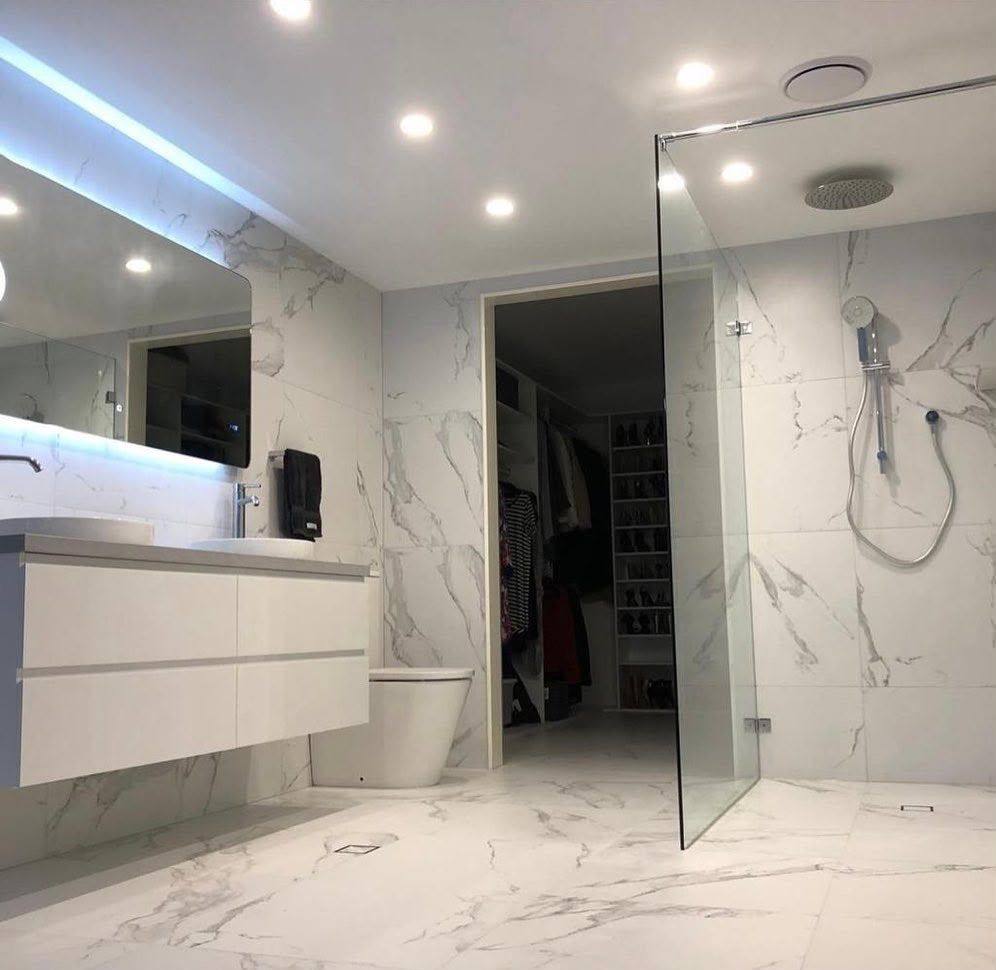 Completed bathroom renovation by INNA GROUP — frameless shower and stone tiling.
